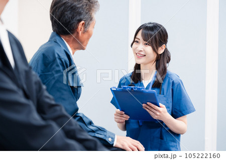 病院の受付で問診をする医療スタッフ 105222160