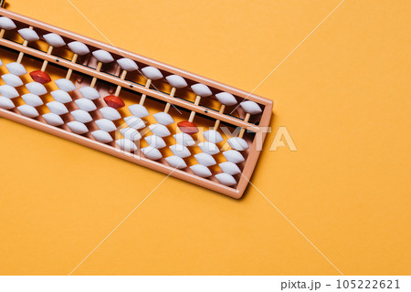 Japanese traditional abacus soroban on orange background. Education and development concept. Back to school, math education, mental mathematics, arithmetic Japanese traditional abacus soroban on orange background. Education and development concept. Back to school, math education, mental mathematics, arithmetic 105222621