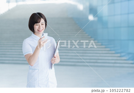 スマホで電話する若い女性看護師 スマホで電話する若い女性看護師 105222782