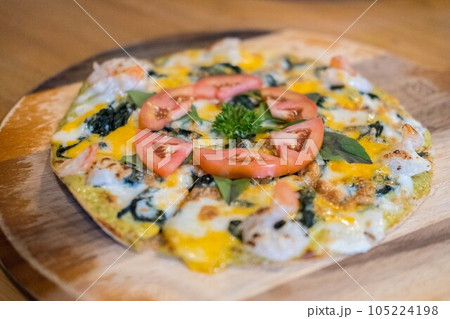 Close up of spinash and tomato Pizza served on the plate Close up of spinash and tomato Pizza served on the plate 105224198