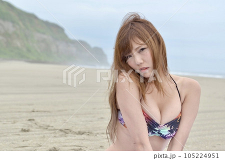 ビーチでポーズをとるビキニの水着を着た若い女性 105224951