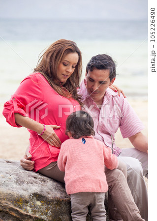 Young couple waiting for their second baby having fun with their baby girl at the beautiful white beach of Lake Tota located in the department of Boyaca at 3,015 meters above sea level in Colombia Young couple waiting for their second baby having fun with their baby girl at the beautiful white beach of Lake Tota located in the department of Boyaca at 3,015 meters above sea level in Colombia 105226490