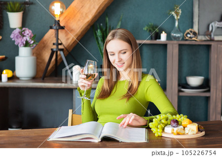Young woman reading an interesting magazine at wooden table Young woman reading an interesting magazine at wooden table 105226754