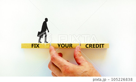 Fix your credit symbol. Concept words Fix your credit on wooden blocks on a beautiful white table white background. Businessman hand. Business, finacial and fix your credit concept. Copy space. 105226838