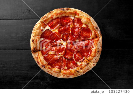 Pizza with pelati tomato sauce, mozzarella, pepperoni and chili pepper Pizza with pelati tomato sauce, mozzarella, pepperoni and chili pepper 105227430