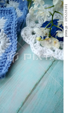 Blue, white crochet elements and orchid. Crochet texture, place for an inscription, adapted for mobile phone 105228101
