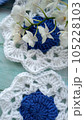 Blue, white crochet elements and orchid. Crochet texture, place for an inscription, adapted for mobile phone 105228103