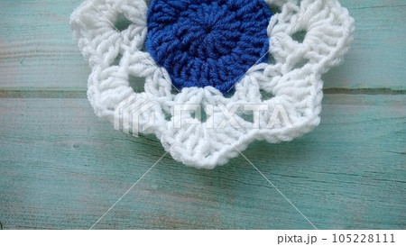 Blue, white crochet elements and orchid. Crochet texture, place for an inscription, adapted for mobile phone Blue, white crochet elements and orchid. Crochet texture, place for an inscription, adapted for mobile phone 105228111