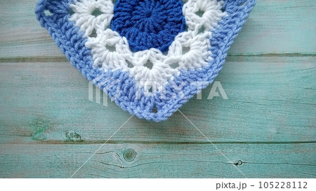 Blue, white crochet elements and orchid. Crochet texture, place for an inscription, adapted for mobile phone Blue, white crochet elements and orchid. Crochet texture, place for an inscription, adapted for mobile phone 105228112
