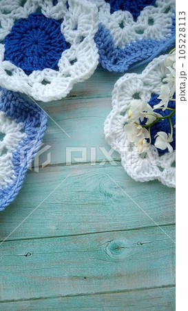 Blue, white crochet elements and orchid. Crochet texture, place for an inscription, adapted for mobile phone Blue, white crochet elements and orchid. Crochet texture, place for an inscription, adapted for mobile phone 105228113