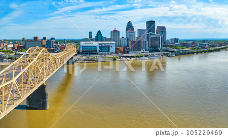 Panoramic aerial rose gold truss bridge over Ohio River heading into skyscraper center Louisville 105229469