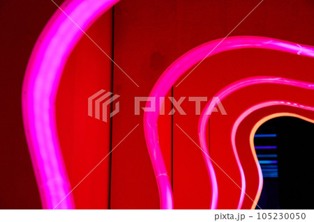 Curved pink neon lines arching towards a black doorway 105230050