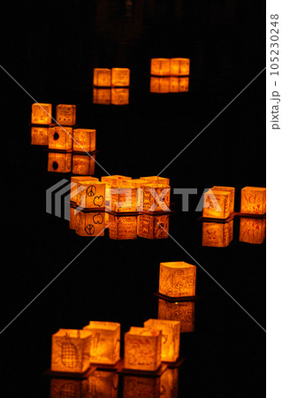 Japanese style lanterns floating in S formation on black pond 105230248