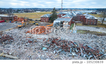 Drone aerial of deconstruction site of old abandoned hospital building with decay at Byron Health Center with multiple scrap piles Drone aerial of deconstruction site of old abandoned hospital building with decay at Byron Health Center with multiple scrap piles 105230639