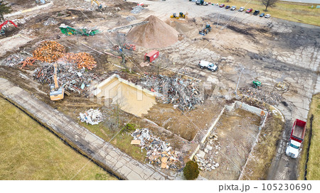 Remnant of a pool at construction zone with piles of scrap and debris 105230690