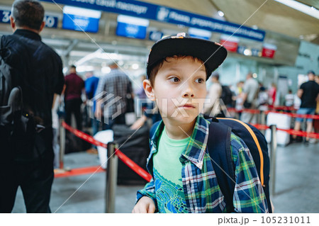 sad caucasian boy in airport with backpack and suitcase. Travelling concept sad caucasian boy in airport with backpack and suitcase. Travelling concept 105231011