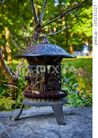 Small metal Tibetan Mongolian Buddhist lantern on rocks in forest 105231227