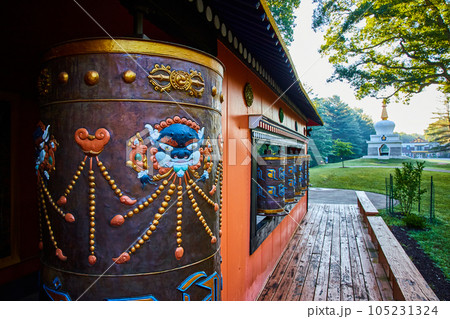 Shrine with several prayer wheels and Chorten structure in background 105231324