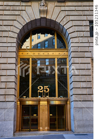 Outside New York City building 26 with golden frame and stone arch over huge entrance Outside New York City building 26 with golden frame and stone arch over huge entrance 105231346