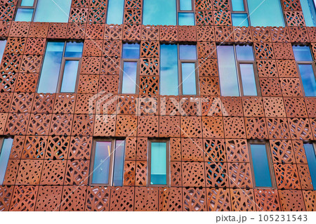 Metal cutout shapes cover exterior building broken up by windows 105231543