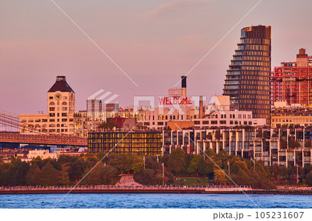 WELCOME sign on building of Brooklyn from coast with waters and buildings around during dusk light 105231607