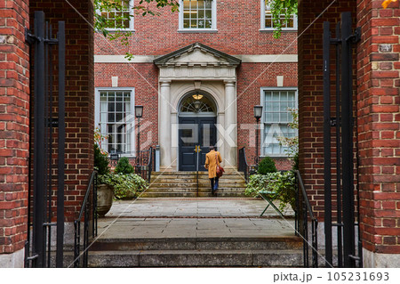 Law student walking through courtyard from brick arches in New York City straight on Law student walking through courtyard from brick arches in New York City straight on 105231693