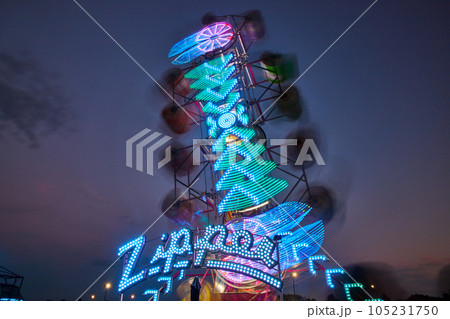 Zipper carnival ride with blurred lights during dusk at county fair 105231750
