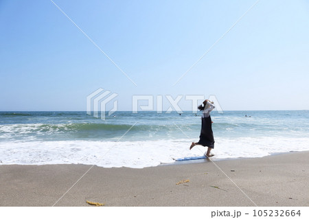砂浜を走る女性真夏の湘南海岸青い空青い海の風景 砂浜を走る女性真夏の湘南海岸青い空青い海の風景 105232664