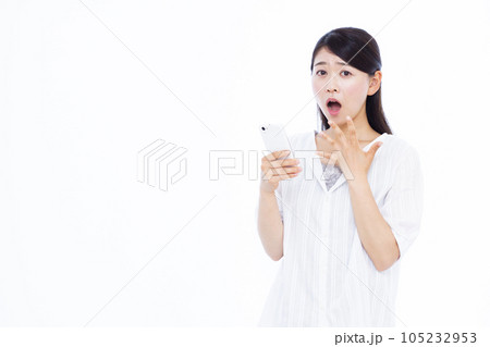 白い背景の前でスマホを持ちビックリしている30代の女性 105232953