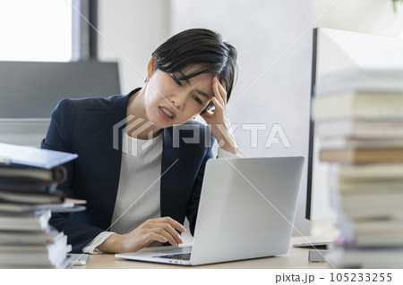 デスクワーク　ノートパソコンの画面を見ながら頭を抱えるビジネスウーマン  105233255