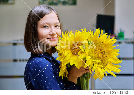 Young happy woman with bouquet of yellow sunflower 105233685