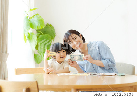 お金の勉強をしている親子 105235109