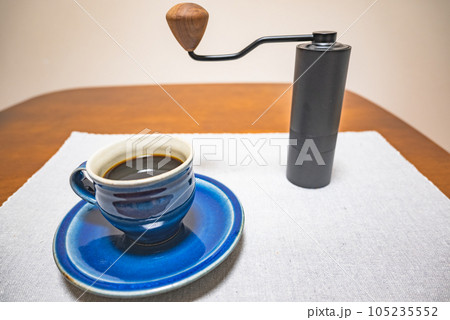 コーヒーカップに注がれたコーヒーとハンドミル コーヒーカップに注がれたコーヒーとハンドミル 105235552