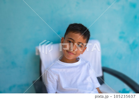 A cute boy with a smiling face healthy and cheerful..The cute boy wearing a white tee shirt spoke and made many expressions of emotions..Studio portrait, health concept with blue background. . A cute boy with a smiling face healthy and cheerful..The cute boy wearing a white tee shirt spoke and made many expressions of emotions..Studio portrait, health concept with blue background. . 105235637