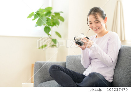カメラの画面を見ながら回想する女性 105237479