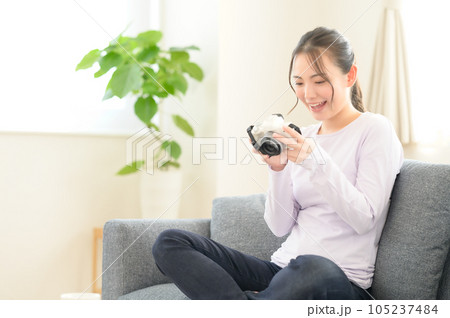 カメラの画面を見ながら回想する女性 105237484