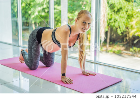 Young pregnant woman doing yoga exercises and meditating at home or yoga studio. Health care, mindfulness, relaxation and wellness concept Young pregnant woman doing yoga exercises and meditating at home or yoga studio. Health care, mindfulness, relaxation and wellness concept 105237544