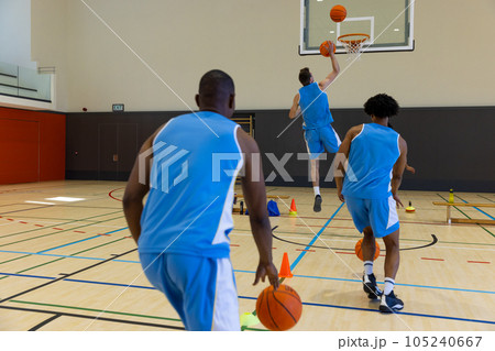 Diverse male basketball players exercising and playing basketball at gym Diverse male basketball players exercising and playing basketball at gym 105240667