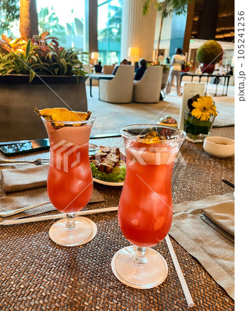 Two glasses of Singapore sling cocktail on a table. High quality photo Two glasses of Singapore sling cocktail on a table. High quality photo 105241256