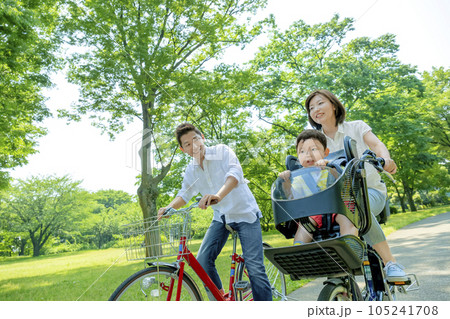 新緑の公園で自転車に乗る親子 105241708