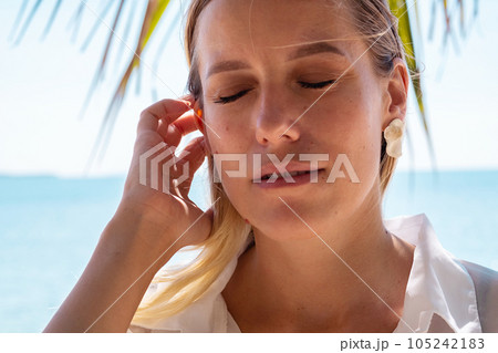 Peaceful lady enjoying the sunshine. Relaxed female spends her free time by ocean. Peaceful lady enjoying the sunshine. Relaxed female spends her free time by ocean. 105242183