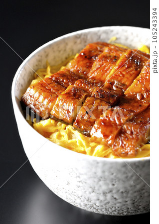 錦糸玉子と鰻の蒲焼きの丼ぶりを黒背景で撮影 105243394