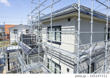 住宅リフォーム 外壁塗装と屋根の張替え作業中の家（空撮） 105247312