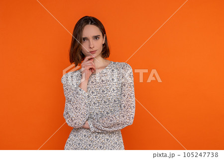 Pensive thoughtful adult woman wearing elegant dress thinking holding phone 105247738