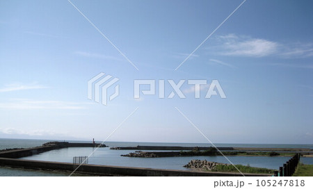日本海と佐渡ヶ島が見える海岸の漁港の防波堤 105247818