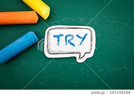 Try. Speech bubble with text and colored pieces of chalk on a green background Try. Speech bubble with text and colored pieces of chalk on a green background 105249266