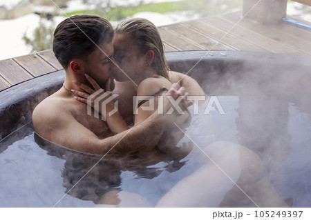 young couple hugging while sitting in a big vat young couple hugging while sitting in a big vat 105249397