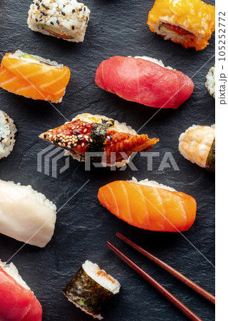 Sushi with chopsticks, top shot. Rolls, maki, nigiri on a black background Sushi with chopsticks, top shot. Rolls, maki, nigiri on a black background 105252772