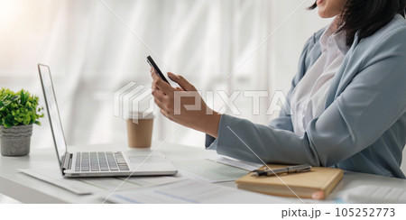 Smiling business woman from work on notification from social media messenger in smartphone device in office 105252773