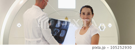 A woman sits near the MRI apparatus, a close-up 105252930